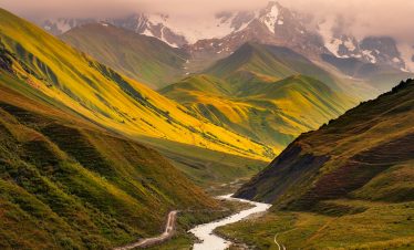 Beautiful sunrise with mountains, river and meadows in Ushguli, Georgia