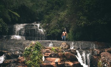Topless man standing near waterfall in kodaikanal, india